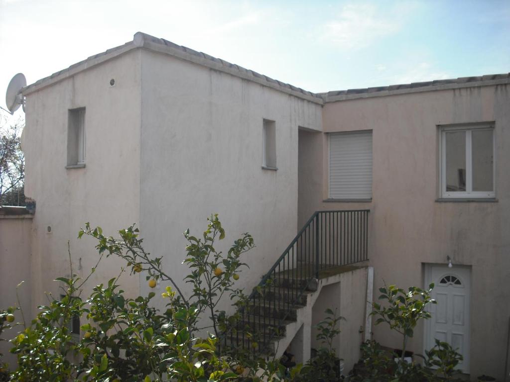 un edificio blanco con una escalera delante en CASAPIANA 05, en San-Gavino-di-Carbini