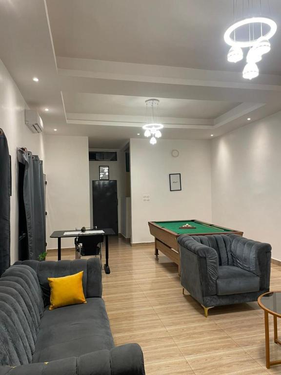 a living room with a couch and a pool table at Villa akassato in Golo-Tokpa