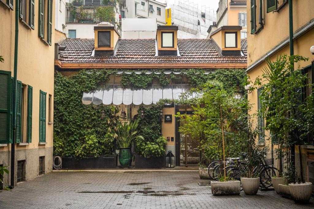 an entrance to a building with a bunch of plants at Stylish Navigli Apartment - Walk to Darsena & Duomo in Milan