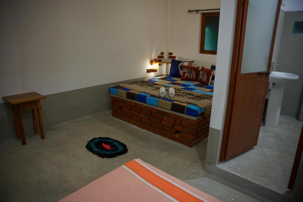 Schlafzimmer mit einem Bett aus Ziegelwand in der Unterkunft Wilpattu Green Cabin in Achchamulai