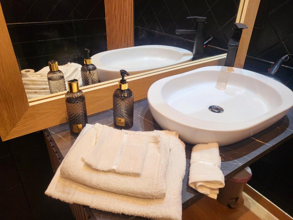 a bathroom sink with towels on a counter in front of a mirror at Roma Luxury Loft in La Giustiniana