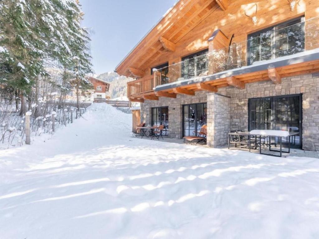 dom ze śniegiem na ziemi przed nim w obiekcie Wasserfall Lodge Krimml w mieście Krimml