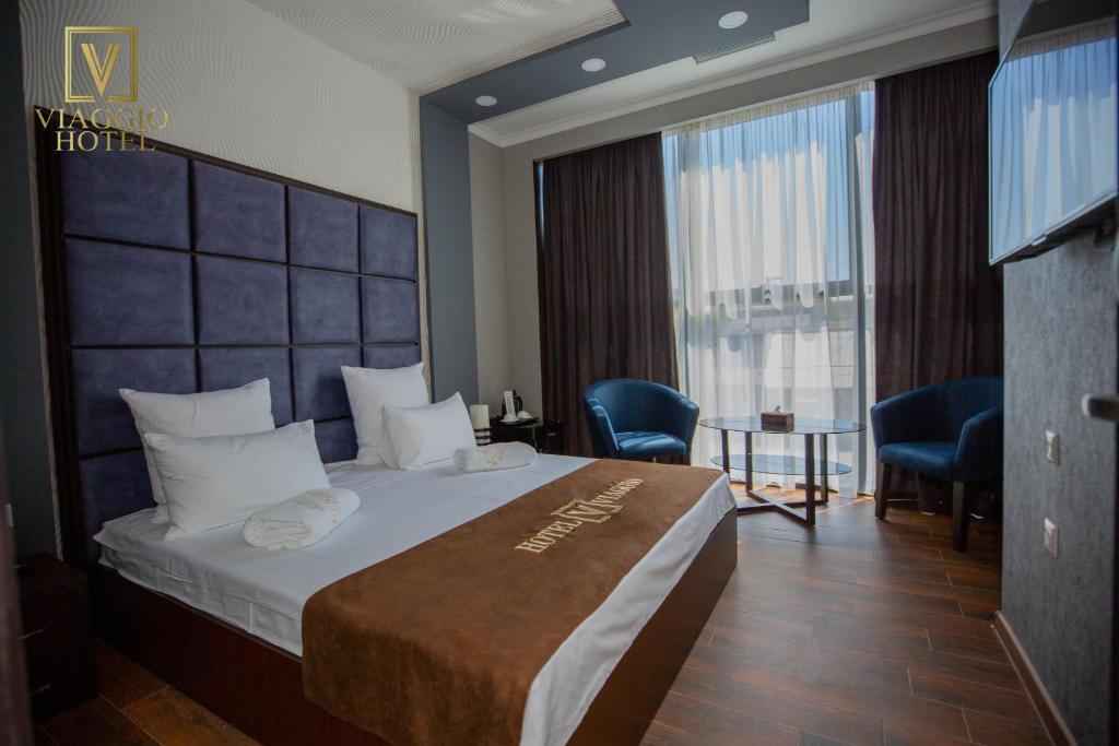 a hotel room with a bed and a large window at Hotel Viaggio in Yerevan