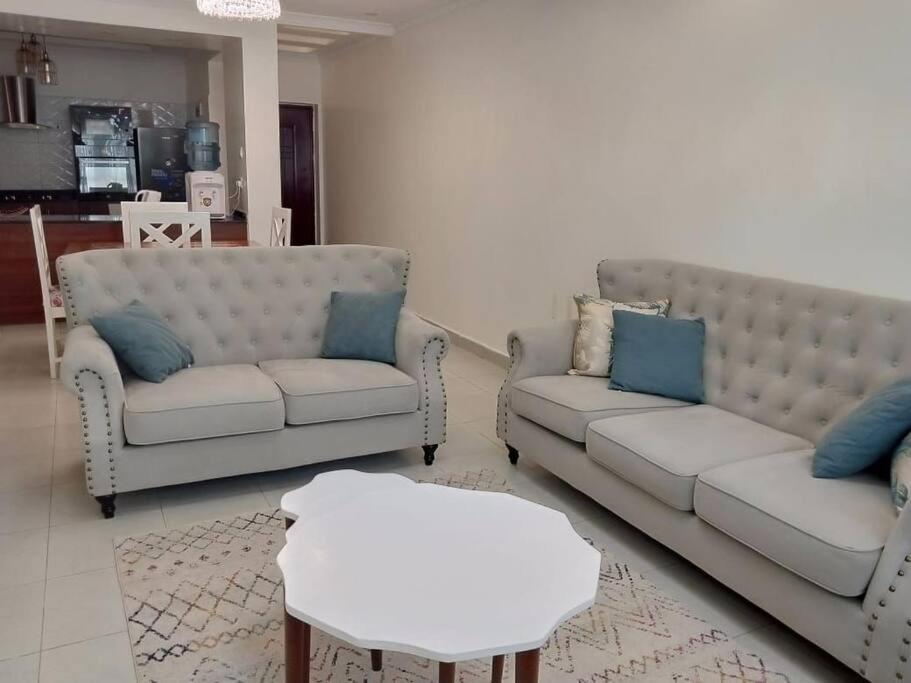 Sala de estar con 2 sofás y mesa en Luxurious Homes AthiRiver, en Athi River