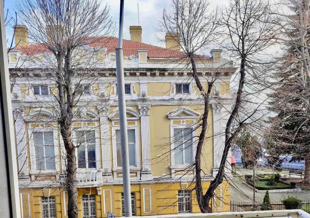 un grand bâtiment jaune avec un toit rouge dans l'établissement Primorski Apartment, à Varna