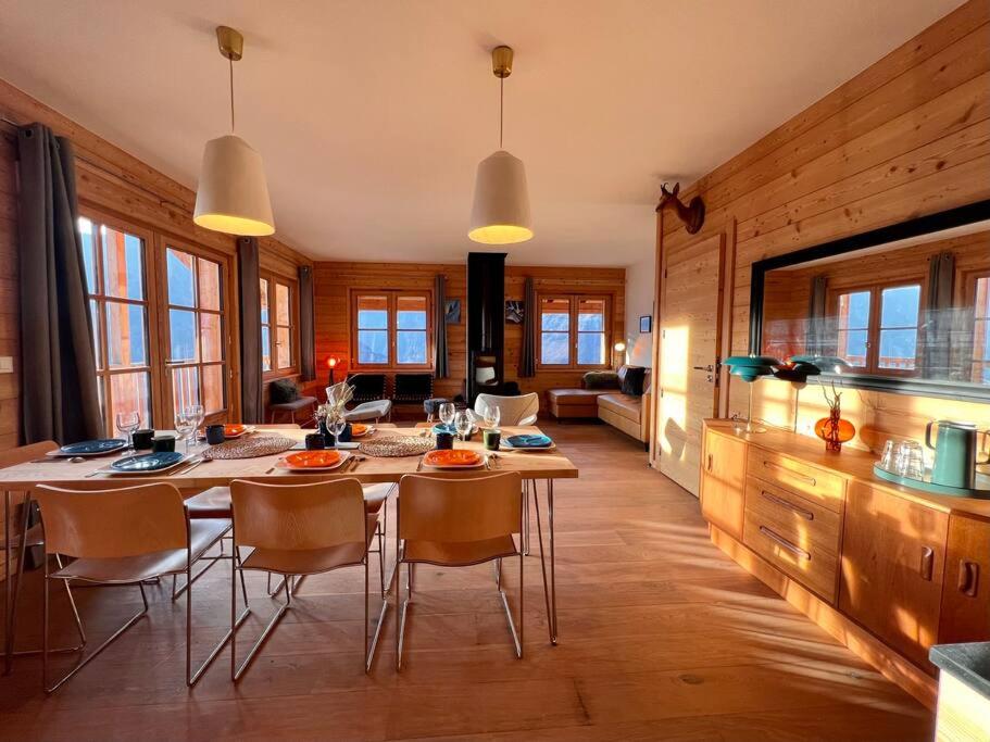 a kitchen and dining room with a table and chairs at Parnasse - Appt 5 étoiles dans Chalet Moderne, vue exceptionnelle terrasse et cheminée in Villard-Reculas
