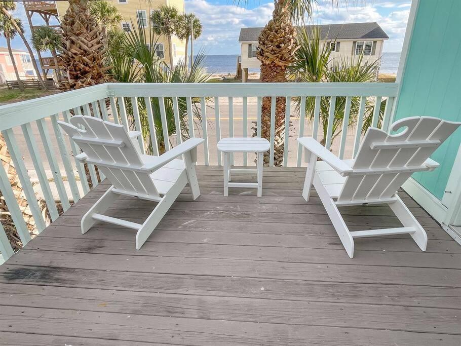 2 weiße Stühle und ein Tisch auf einer Veranda in der Unterkunft The Gentleman Pirate in Edisto Island