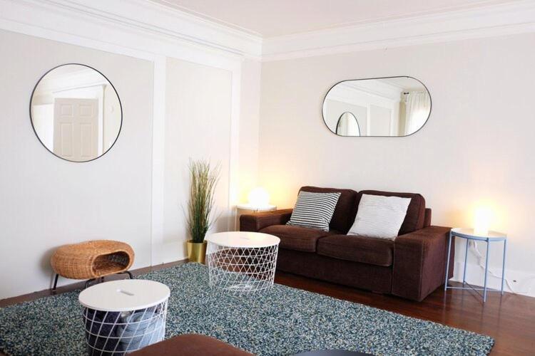 a living room with a couch and two mirrors at Kohzy ( Koreatown ) in Los Angeles