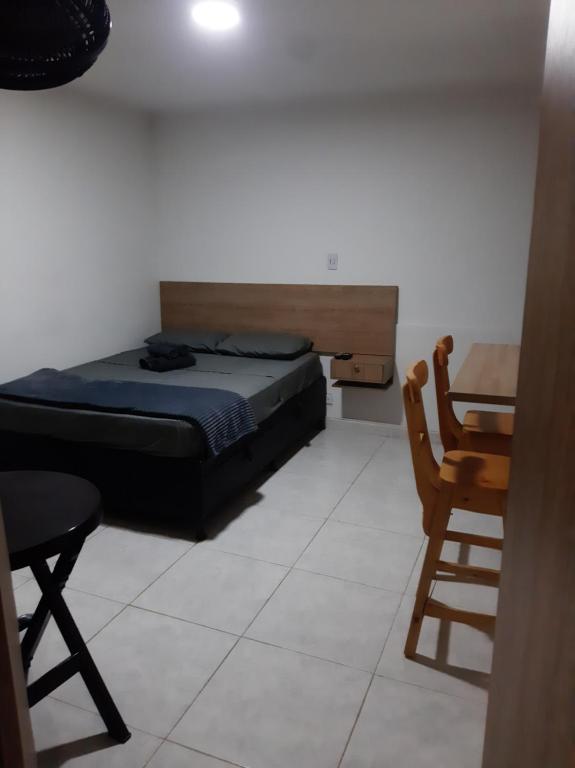 a bedroom with a bed and a table and a chair at Mundo Turismo Hostel in Medellín
