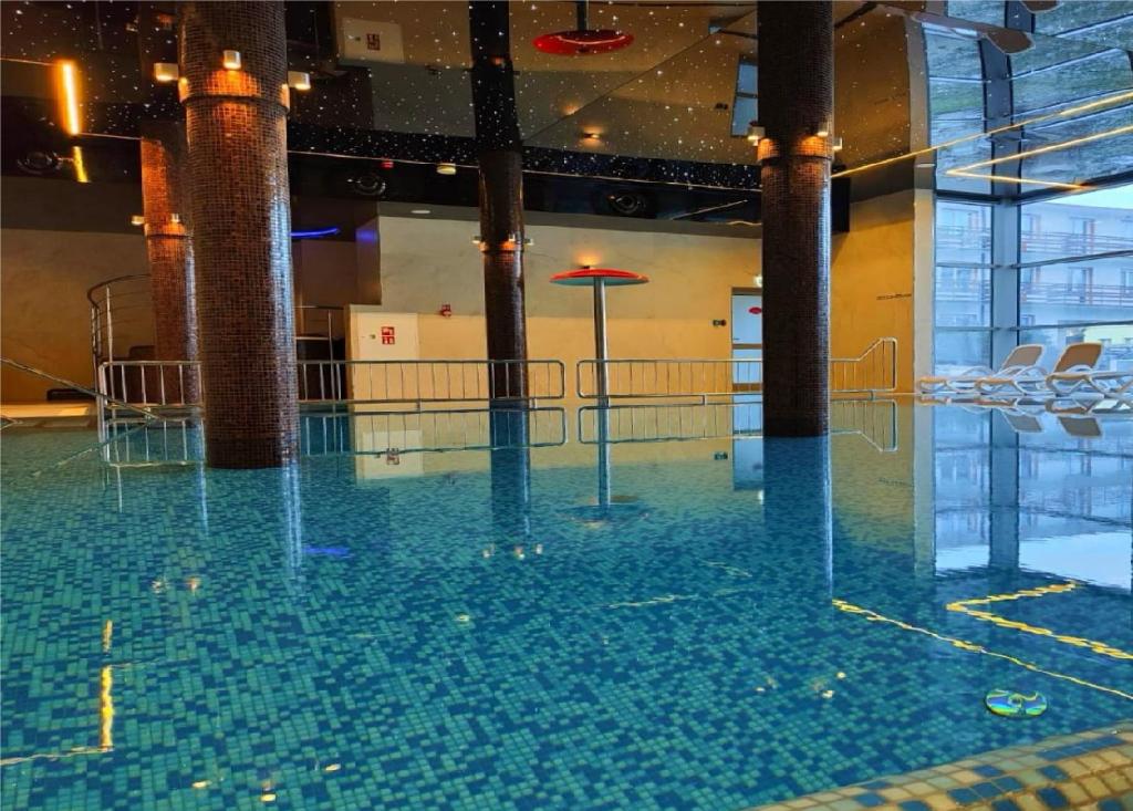 einen Pool mit Wasser in einem Gebäude mit Stühlen in der Unterkunft Hotel SKAL Medi SPA & Resort in Ustronie Morskie