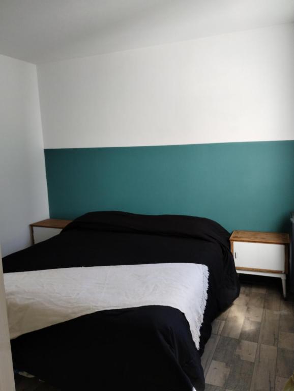 een slaapkamer met een bed en een blauwe muur bij Inhala y exhala in Mar del Plata