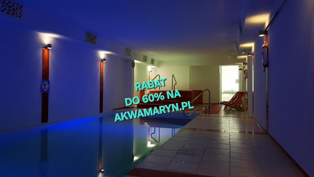 a room with a blue wall with a sign on it at Akwamaryn Spa Niechorze in Niechorze