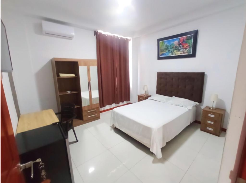a hotel room with a bed and a desk and a room at D'eluxe Hotel Talara ubicado a 5 minutos del aeropuerto y a 8 minutos del Centro Civico in Talara