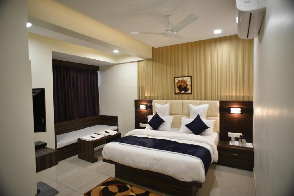 a bedroom with a large bed and a television at Hotel Royal Residency in Vadodara