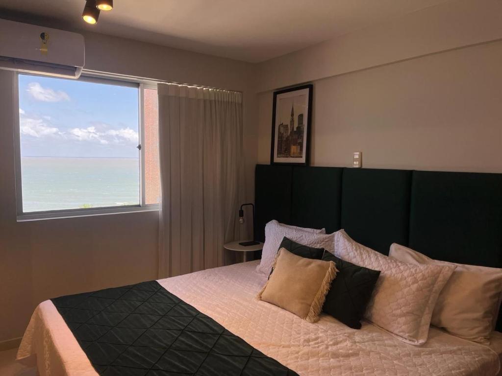 a bedroom with a large bed with a large window at American Flat in São Luís