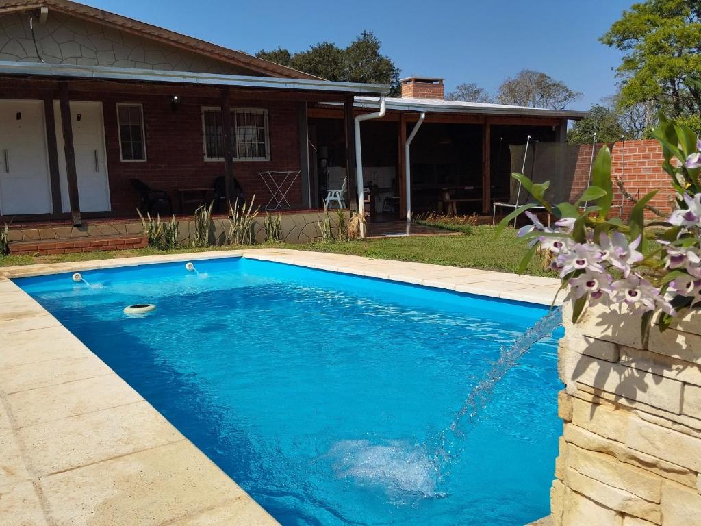 a swimming pool in front of a house at Don Alejandro Apart Iguazu in Puerto Iguazú