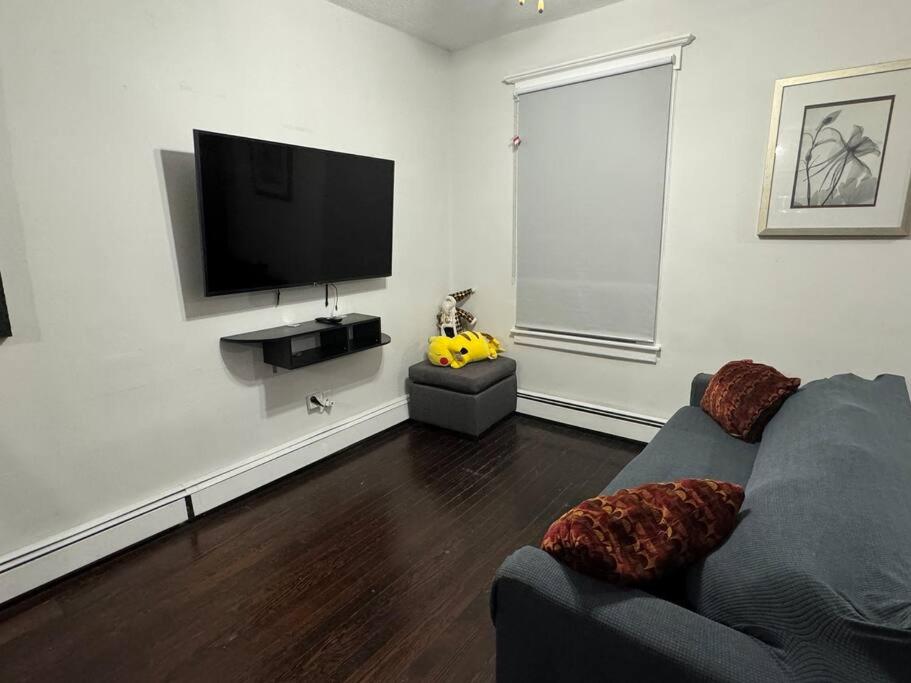 a living room with a couch and a flat screen tv at NYC Gateway: Cozy Home with Easy Access in Passaic