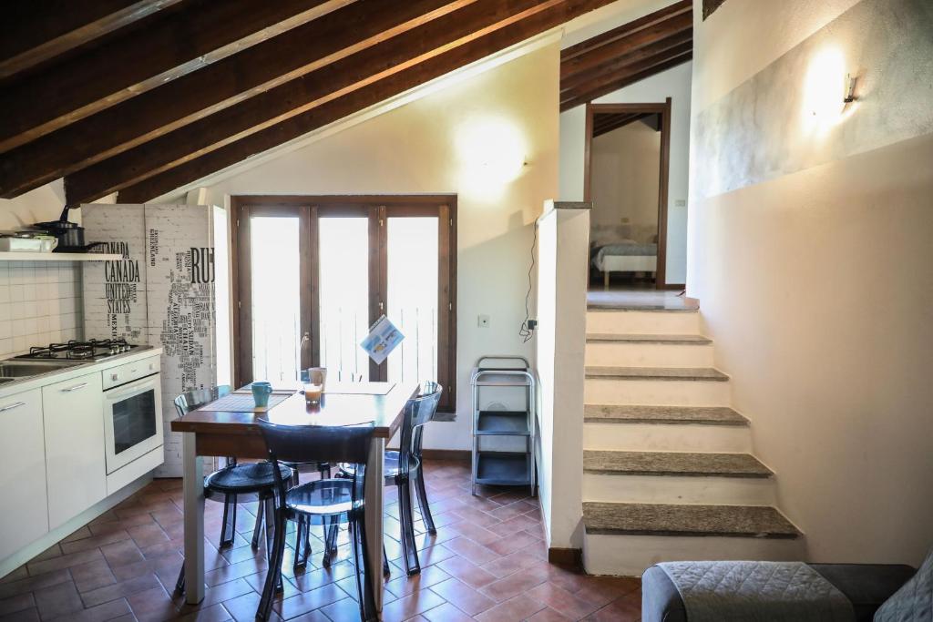 uma cozinha com uma mesa e cadeiras e uma escadaria em Piccinardi house - appartamento 4 posti letto em Crema