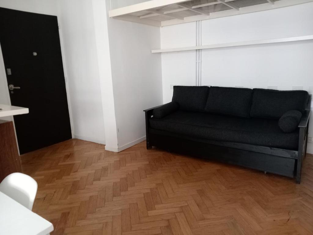 a black couch in a room with a wooden floor at Excelente departamento en Retiro in Buenos Aires