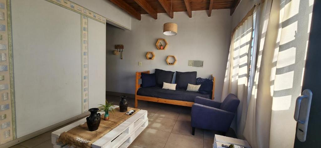 um quarto com uma cama azul e uma cadeira azul em DEPARTAMENTO Mendoza em Las Heras