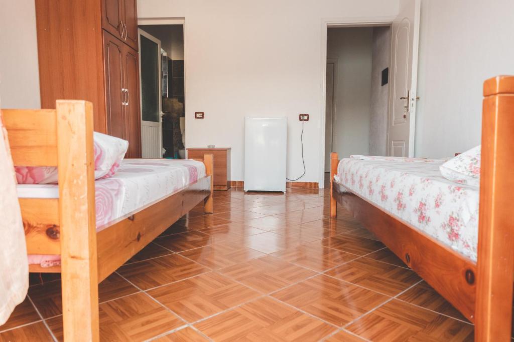 1 dormitorio con 2 camas y suelo de madera en Room with amazing sea view, en Himare