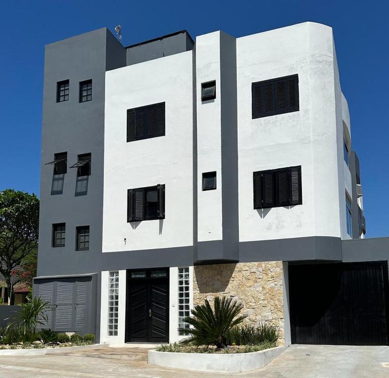 een wit gebouw met zwarte ramen bij Residencial Marítimos in Torres