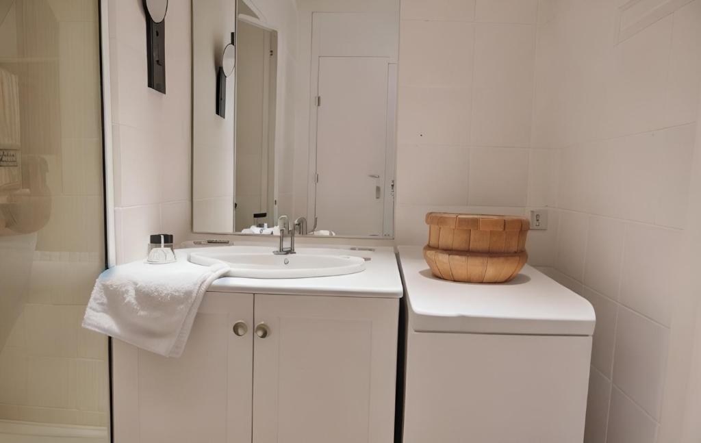 a white bathroom with a sink and a mirror at FRGK "Studio Croisette face mer" in Cannes