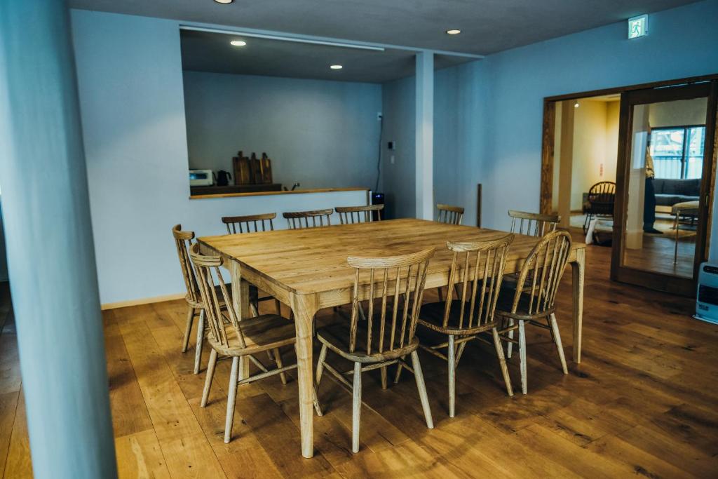 石打丸山スキー場徒歩30秒一棟まるまる貸切フルリノベーションのお宿 في Seki: غرفة طعام مع طاولة وكراسي خشبية