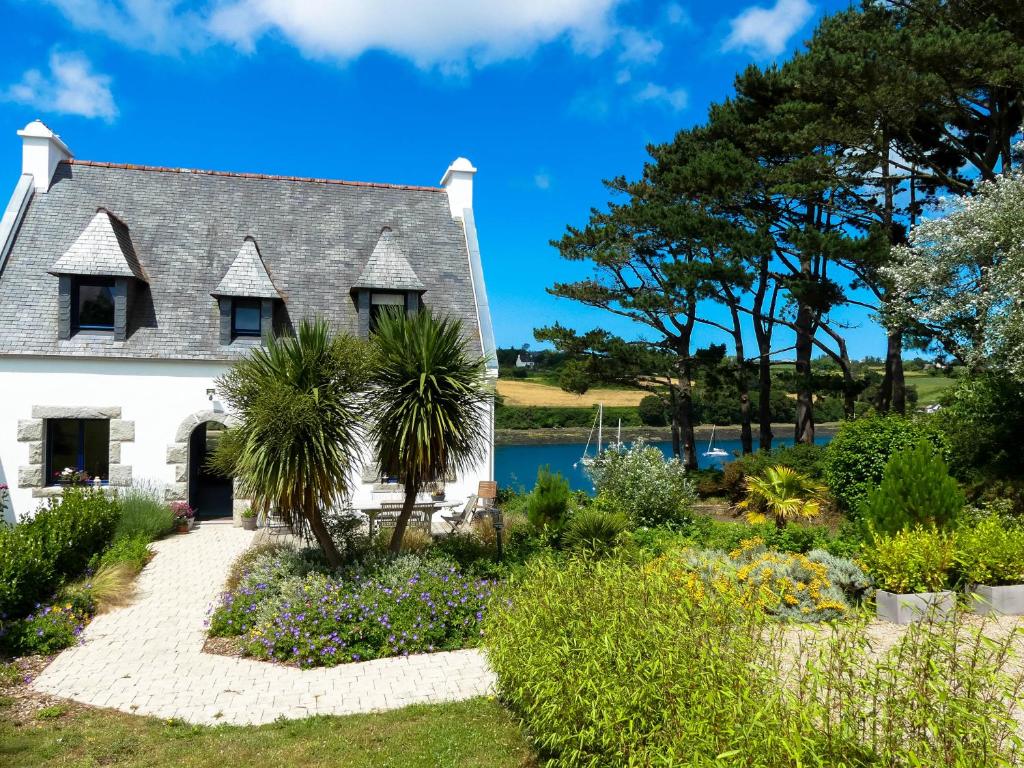 una casa con jardín frente a un lago en LE CLOS DES ABERS en Saint-Pabu