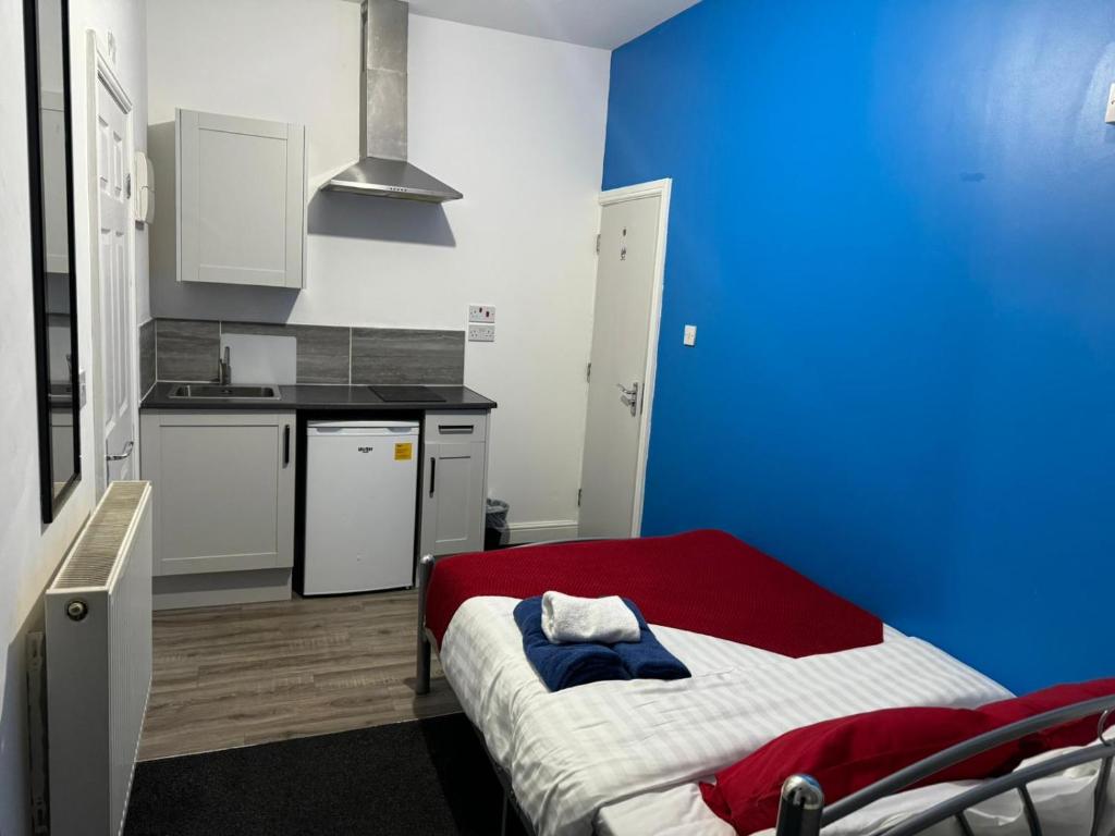 um quarto azul e branco com uma cama e uma cozinha em Gregory Boulevard - Stay Sleep Rest em Nottingham