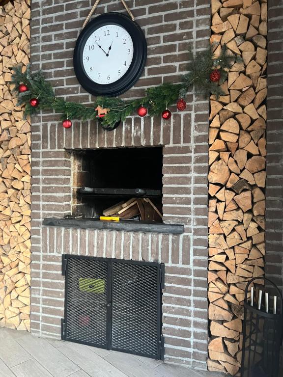 a clock on a brick fireplace with christmas decorations at Roman House Borsa in Borşa