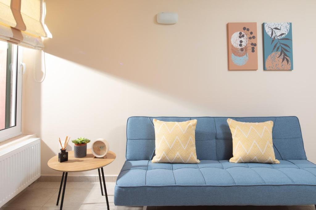 a blue couch in a living room with a table at Τ&G Home in Corfu Town