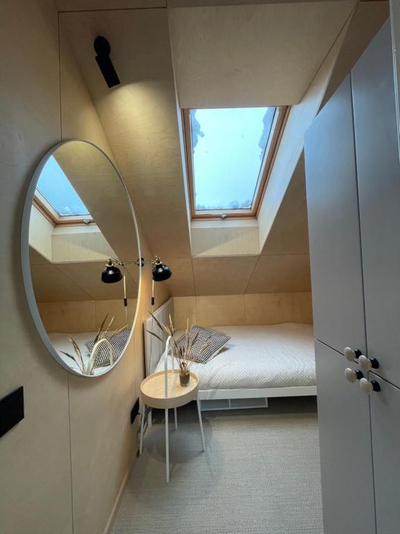 a small bedroom with a mirror and a bed at Amber bay in Juodkrantė