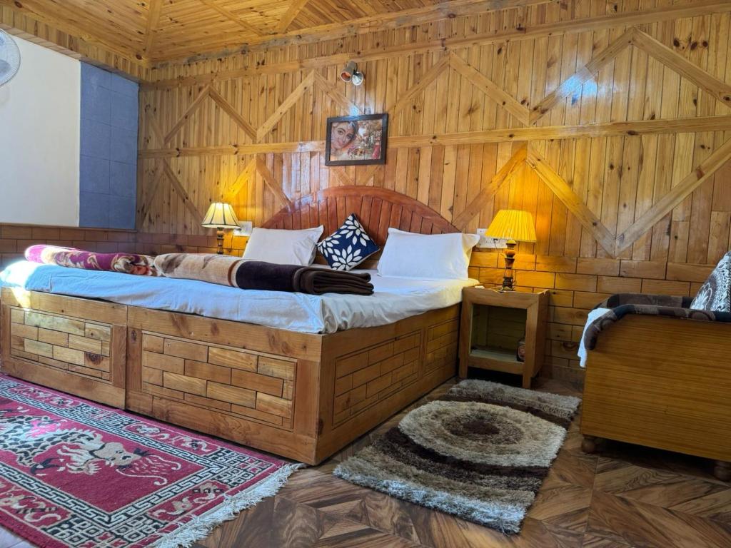 a bedroom with a large bed in a wooden room at Nest Villa Homestay in Nagar