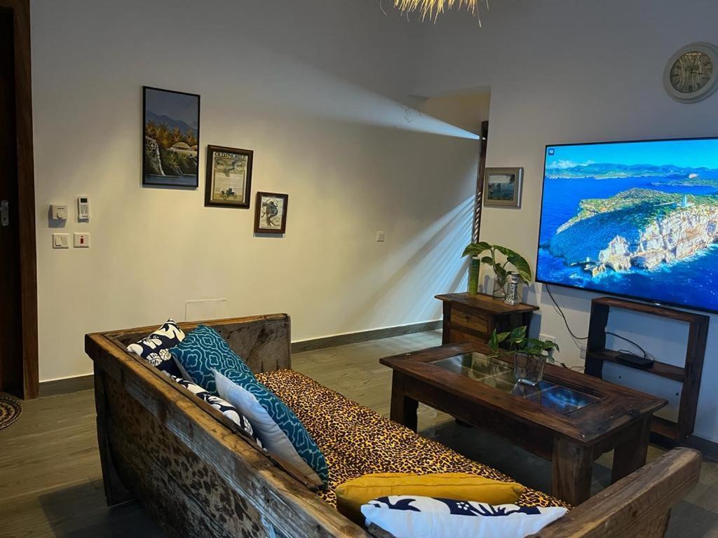 Villa tangawizi kendwa في كيندوا: غرفة معيشة مع أريكة وتلفزيون بشاشة كبيرة