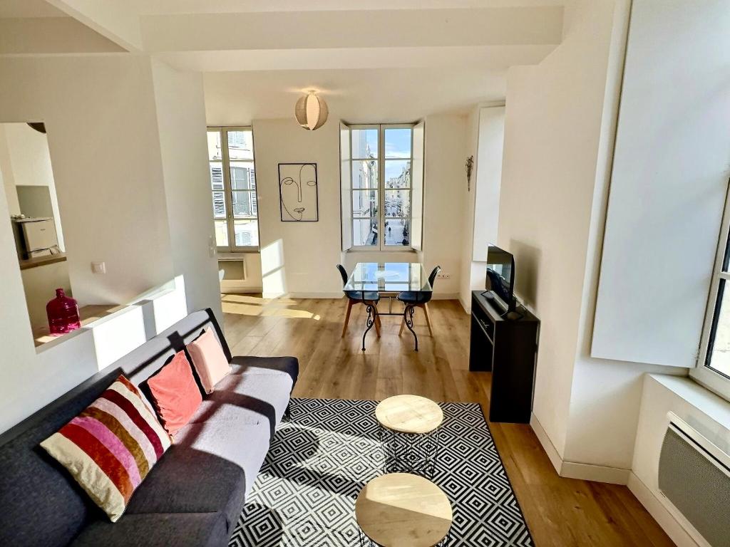 een woonkamer met een bank en een tafel bij WonderHost, au cœur du quartier du château in Pau