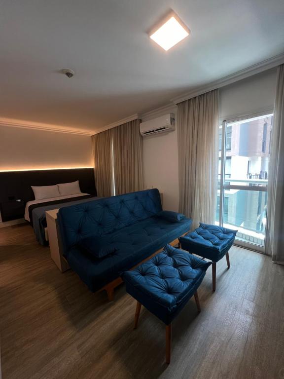 HOTEL PERDIZES - FLAT Executivo - 504 في ساو باولو: غرفة معيشة مع أريكة زرقاء وسرير