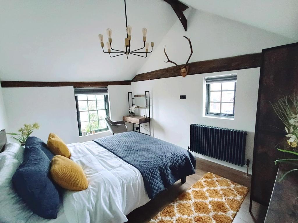 a bedroom with a large bed and a chandelier at Stansted Airport Cottage in Bishops Stortford