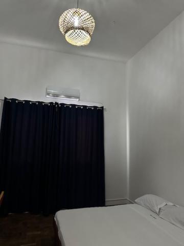 ein Schlafzimmer mit einem Bett und einem schwarzen Vorhang in der Unterkunft Pousada de Namacurra 