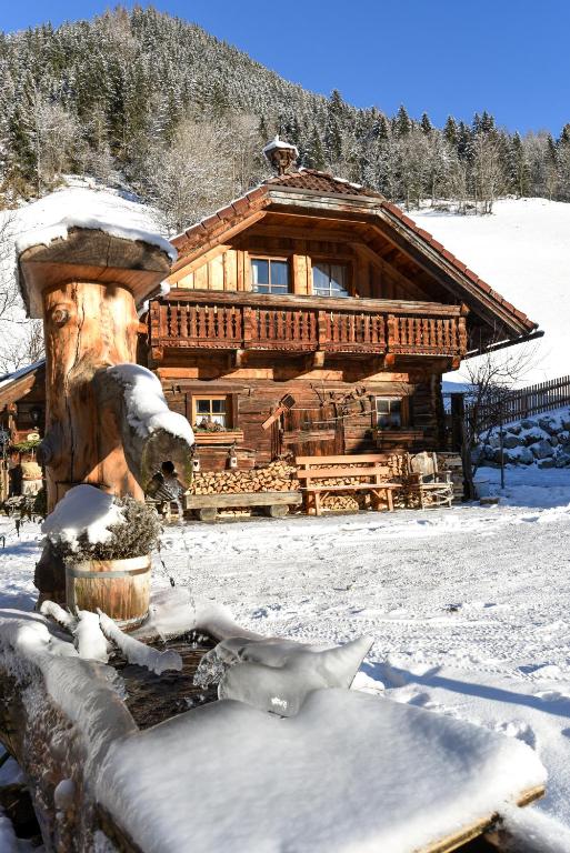 a log cabin in the snow with a statue in front at Chalet Auer's Zuahäusl in Schladming