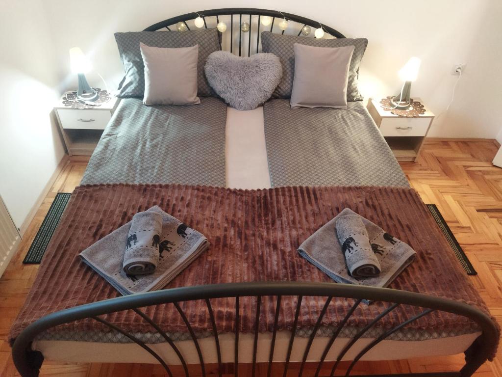 ein Schlafzimmer mit einem Bett mit zwei Nachttischen in der Unterkunft DORA Apartman in Palić