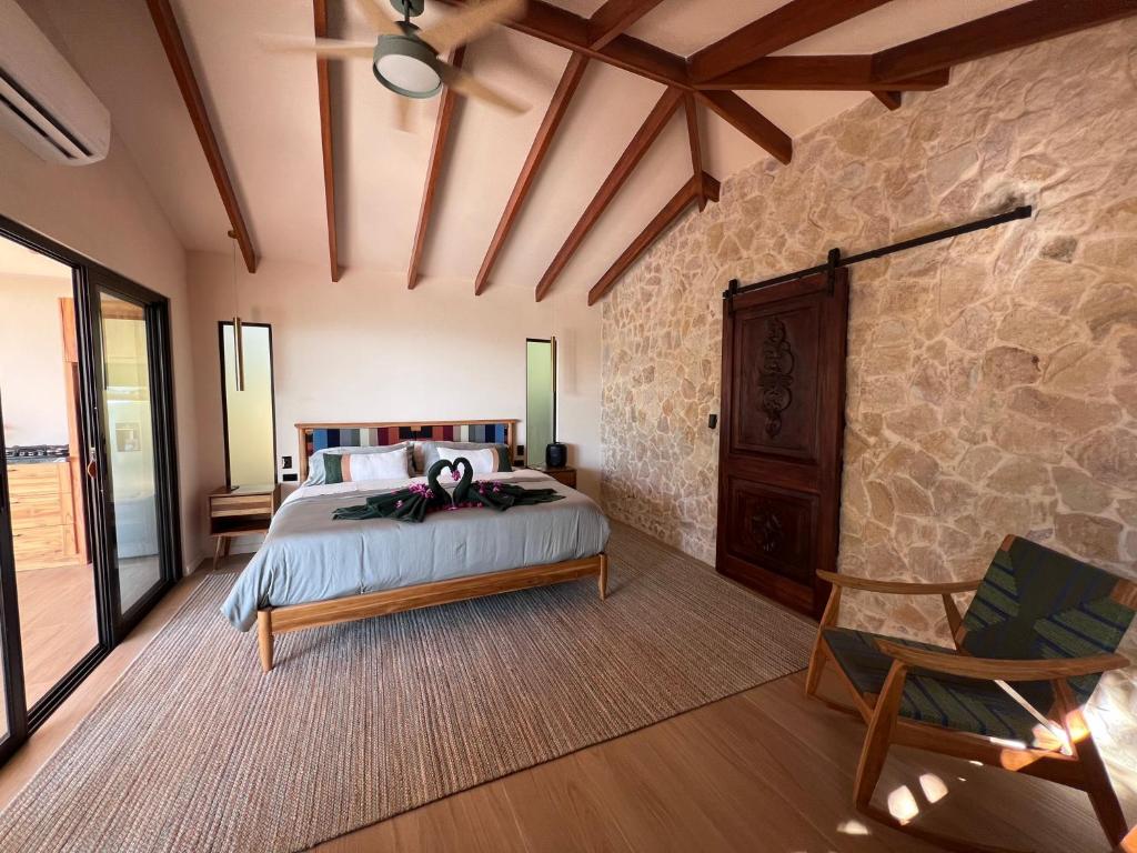 a bedroom with a bed and a stone wall at Monkey House in Dominicalito