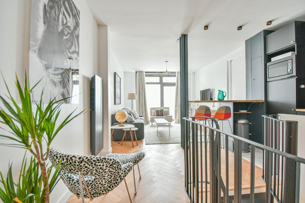 un salon avec un escalier et une cuisine avec une chaise dans l'établissement Duplex à Paris Saint-Ambroise, à Paris