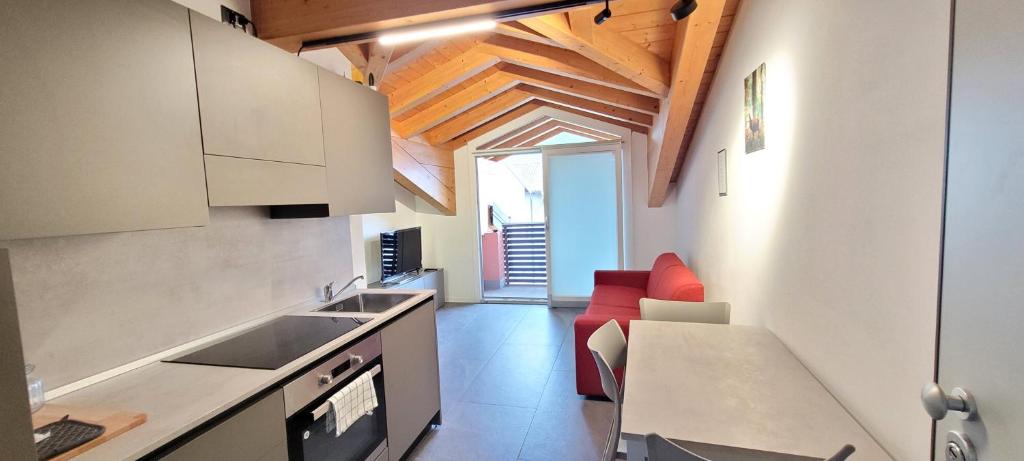 a kitchen with a sink and a red couch at Residence La Corte di San Rocco in Cremeno
