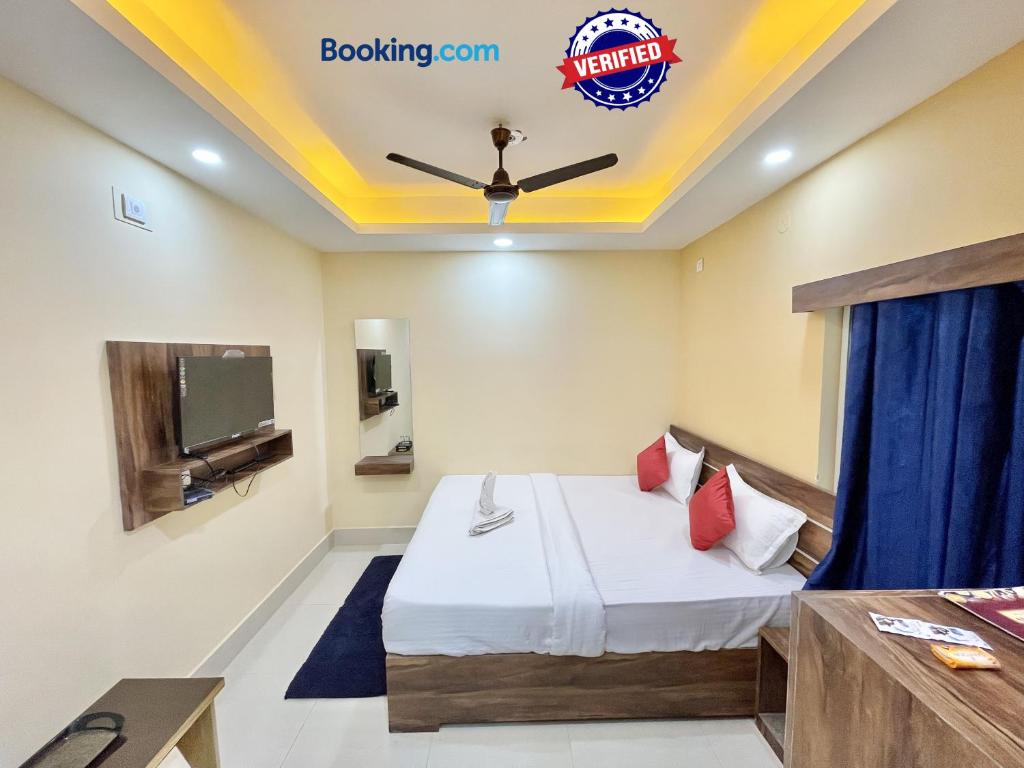 Habitación de hotel con cama y TV en Hotel Swapna Inn, en Puri