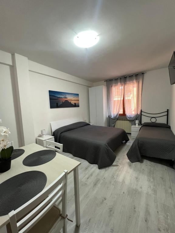 a bedroom with two beds and a table in it at Your home outlet 4 in Serravalle Scrivia