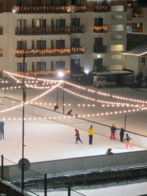 un gruppo di persone che pattinano su una pista di pattinaggio con luci di Tatra K2, app.42, Bakuriani a Bakuriani