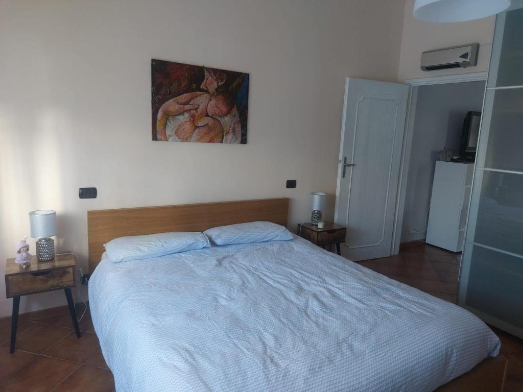 1 dormitorio con 1 cama y una pintura en la pared en Casa di Gina en Rosignano Solvay
