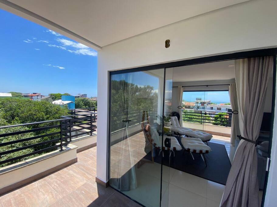 a house with a balcony with a view of the ocean at Linda cobertura, vistas para o mar a 300m da praia in Florianópolis