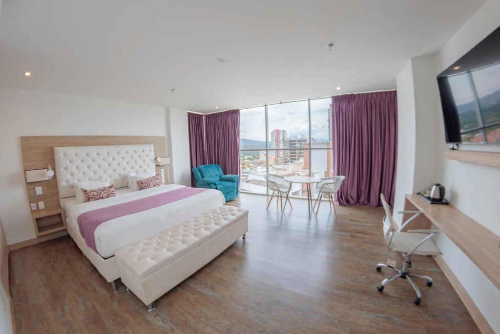 布卡拉曼加的住宿－Hotel Roseliere Bucaramanga，酒店客房带一张床、一张桌子和椅子
